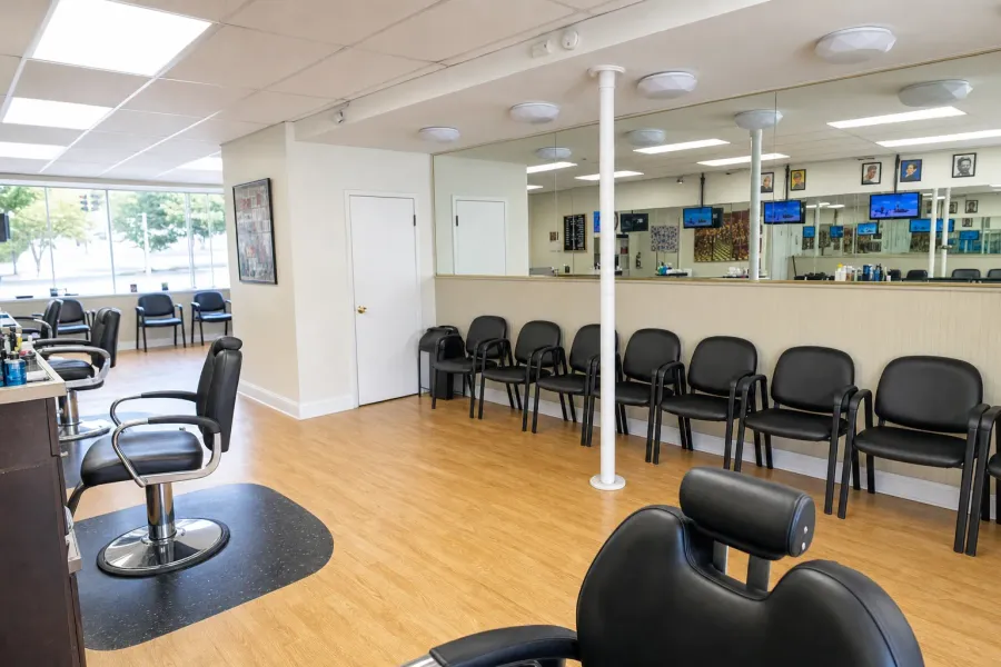 Inside Camp Ave Barbershop — mirrors, black chairs, light wood floor